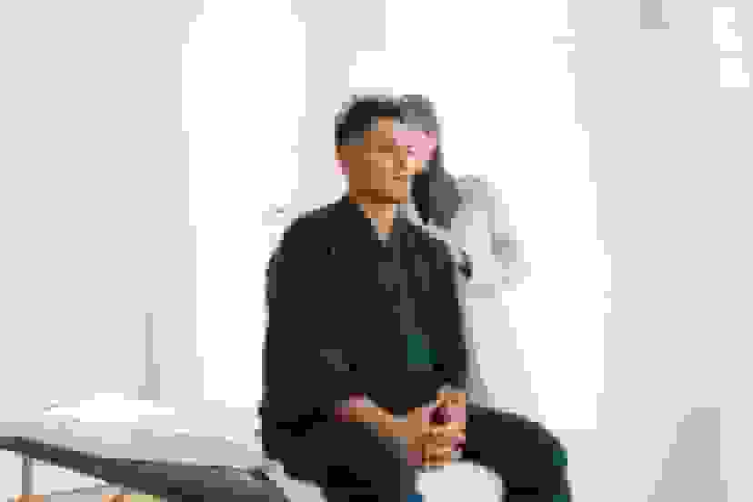 Injured worker receiving a back exam from a healthcare provider to assess workplace injury and determine treatment.